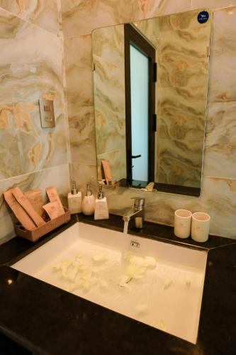 a bathroom with a sink and a mirror at Havana Con Dao Hotel in Con Dao