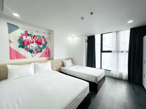 a hotel room with two beds and a painting on the wall at Moana Hotel Nha Trang in Nha Trang