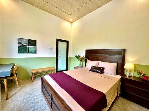 a bedroom with a large bed and a desk at Rustic Homeaway - Stay with the local in Phong Ðiền
