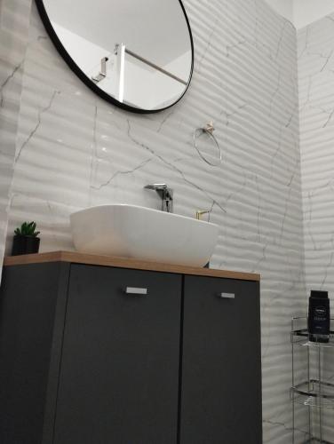 a bathroom with a sink and a mirror on the wall at Garsoniera P2 in Craiova