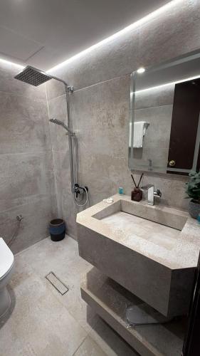 a bathroom with a sink and a shower and a mirror at جناح خاص في أجنحة طيبة مكارم in Medina