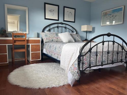a bedroom with a bed and a desk and a mirror at Mountain Guesthouse Bed and Baking in Radium Hot Springs
