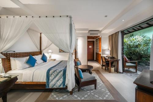 a bedroom with a king sized bed and a desk at Rama Beach Resort and Villas in Kuta