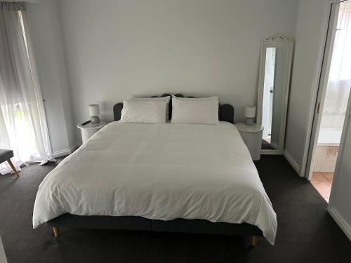 a large white bed with white sheets and pillows at Holiday fun Mildura in Mildura