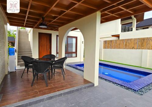 a patio with a table and chairs next to a swimming pool at Maria Clara Villas in Panabo