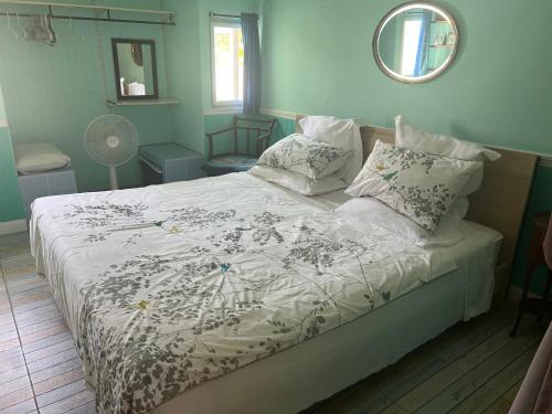 a bedroom with a bed with a white comforter at Charming quirky Thai style house in Hua Hin