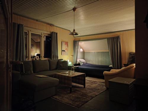 a living room with a couch and a bed at Landgård Feriehus, Trysil sentrum, only a 5 minutes drive in Trysil