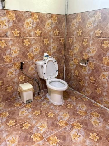 a bathroom with a toilet with flowers on the tiles at Blueka Hostel Ko Chang in Khlaung Phai Bae