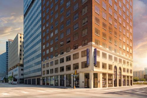 a building on a city street with tall buildings at Hampton Inn & Suites Dallas Downtown in Dallas