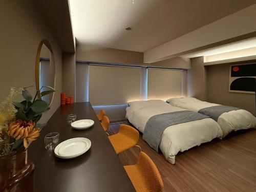 a bedroom with a bed and a table and chairs at Clio Matoba by b hotel - Classic Studio with Kitchen near Station in Ōsukachō