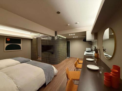 a bedroom with a bed and a kitchen with a counter at Clio Matoba by b hotel - Classic Studio with Kitchen near Station in Ōsukachō