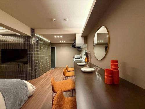 a bedroom with a bed and a vanity with orange chairs at Clio Matoba by b hotel - Classic Studio with Kitchen near Station in Ōsukachō