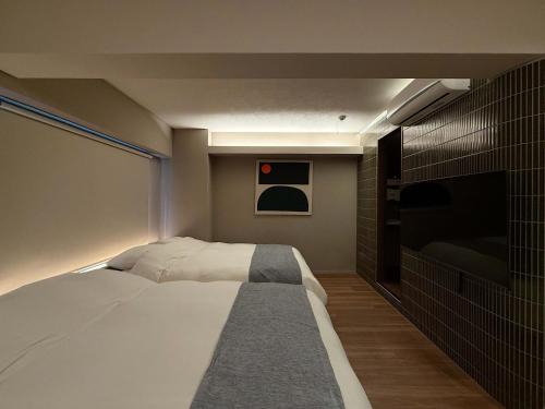 a bedroom with a bed and a flat screen tv at Clio Matoba by b hotel - Classic Studio with Kitchen near Station in Ōsukachō