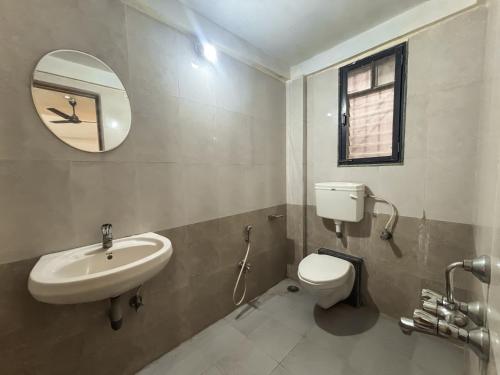 a bathroom with a sink and a toilet and a mirror at Oreo Villa with Swimming Pool in Mahabaleshwar