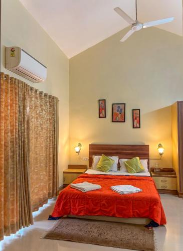 a bedroom with a bed with a red blanket at Oreo Villa with Swimming Pool in Mahabaleshwar