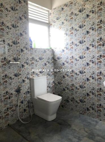 a bathroom with a toilet in a room at Nirmalahomestay in Polgasowita