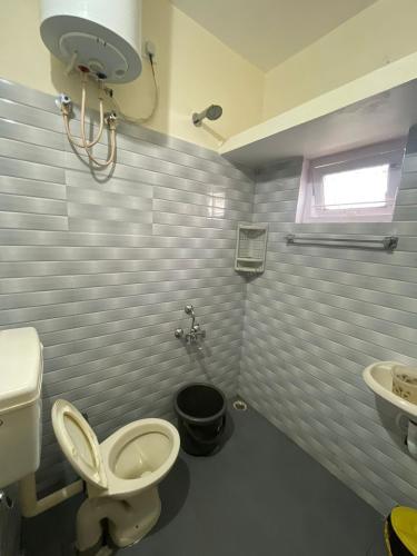 a bathroom with a toilet and a sink at Sky High Villa - Ooty in Ooty