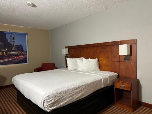 a hotel room with a large bed and a chair at Americas Best Value Inn Fargo in Fargo