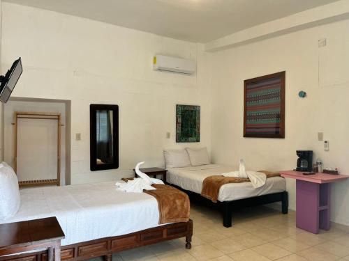 a hotel room with two beds and a table at Casa Papalo in Palenque