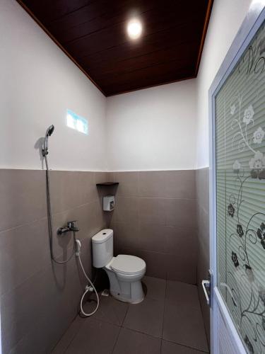 a bathroom with a toilet and a shower at SALWA Homestay in Kuta Lombok