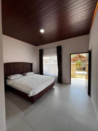 a bedroom with a large bed with a wooden ceiling at SALWA Homestay in Kuta Lombok