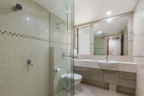 a bathroom with a shower and a toilet and a sink at Nouvelle in Noosaville