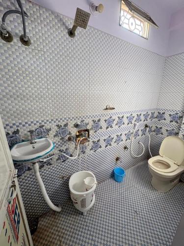 a bathroom with a sink and a toilet in it at Khandelwal Guest House in Ujjain