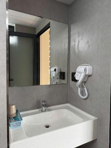 a bathroom sink with a hair dryer and a mirror at Toàn Thịnh Hotel in Da Lat