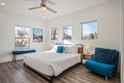 a bedroom with a bed and a blue chair at Timber & Tin D 2Bed 2Bath w Pool & Rooftop Deck in Kanab