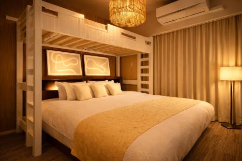 a bedroom with a large white bed in a room at 国際通り徒歩5分 ホテルライクコンドミニアム 自転車3台無料 だるまマンション903 in Naha