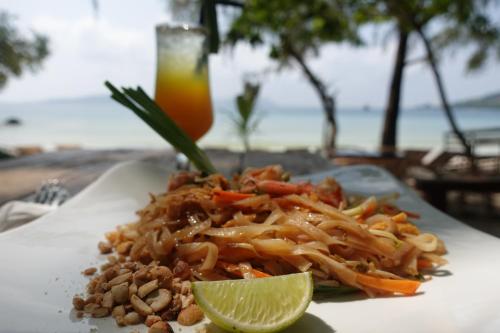 un piatto di cibo con noodles e uno spicchio di lime di Rock Sand Hostel a Phumĭ Kâoh Rŏng