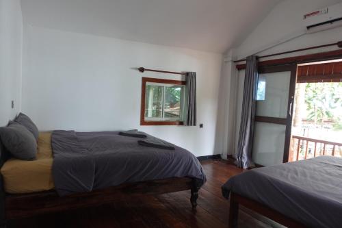 una camera da letto con due letti e una finestra di Rock Sand Hostel a Phumĭ Kâoh Rŏng