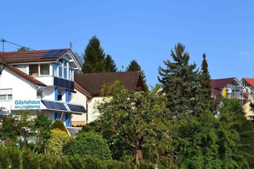 a white building with trees in front of it at Gästehaus am Lindenweg in Meersburg