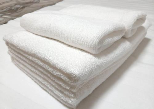 a stack of white towels sitting on a table at コーポラス十日市 - supported by COCOSTAY in Hiroshima