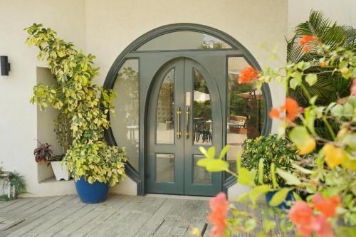 a blue door on a house with plants at Ambiance Boutique Art Hotel Karachi in Karachi