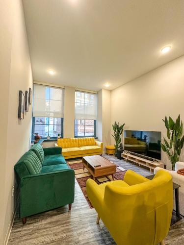 a living room with yellow and green furniture at Your Downtown Oasis, Pool Gym in Building Steps from Dining and Top Sights in Cleveland