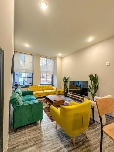 a large living room with yellow and green furniture at Your Downtown Oasis, Pool Gym in Building Steps from Dining and Top Sights in Cleveland