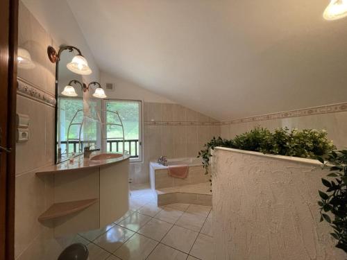 a bathroom with a tub and a sink and a bath tub at Chez garcia in Urrugne