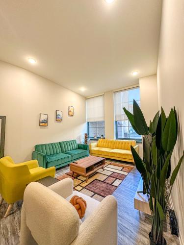 a living room with yellow and green furniture at Your Downtown Oasis, Pool Gym in Building Steps from Dining and Top Sights in Cleveland