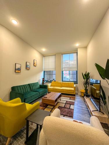 a living room with yellow and green couches at Your Downtown Oasis, Pool Gym in Building Steps from Dining and Top Sights in Cleveland
