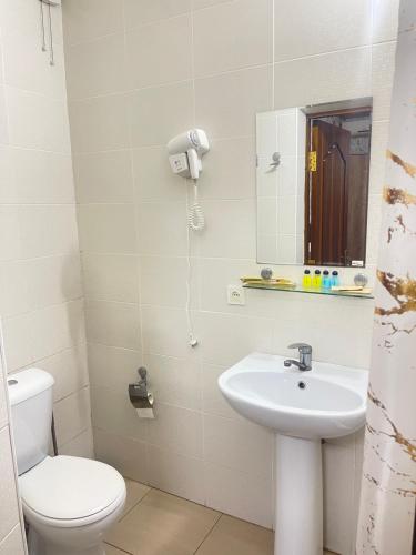 a bathroom with a sink and a toilet and a mirror at GLOBUS Avenue Hotel in Yakkasaray