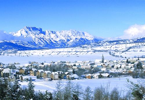 uma cidade na neve com montanhas ao fundo em Lamour em Ancelle