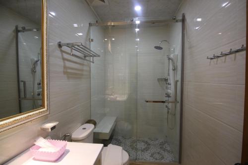 a bathroom with a shower and a toilet and a sink at Takhmao Good Health Hotel in Ta Khmau