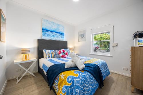 a bedroom with a bed and a window at Smugglers Cove - Seaside Comfort near Dining & Shops in Victor Harbor