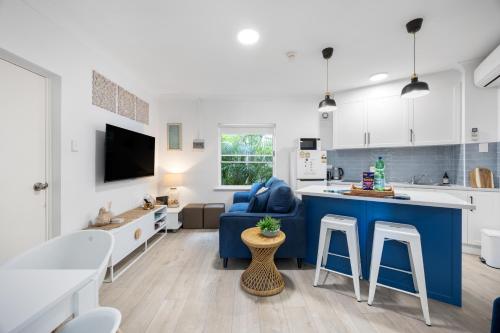 a kitchen and living room with a blue island in a room at Smugglers Cove - Seaside Comfort near Dining & Shops in Victor Harbor
