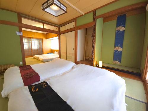 a bedroom with two beds with white sheets at sora in Osaka