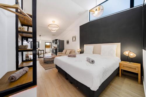 a bedroom with a large bed and a living room at La Fabrik' - Studio avec jacuzzi privé à La Réunion in Le Tampon