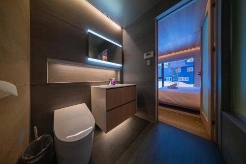 a bathroom with a toilet and a sink and a window at Eminence in Hakuba