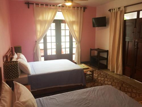 a bedroom with two beds and a window at Hotel La Polvora in Granada