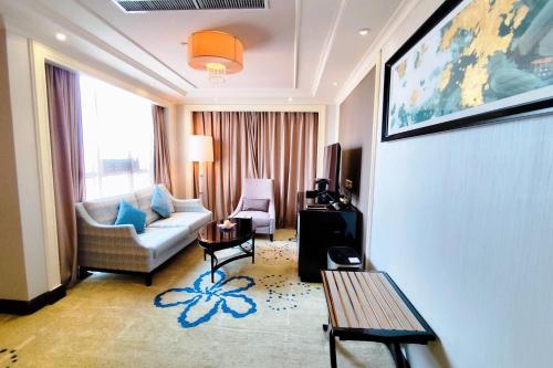 a living room with a couch and a table at Ramada Plaza Tianlu Hotel in Wuhan